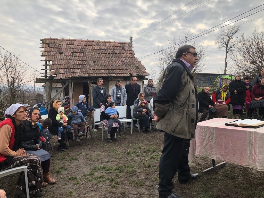 Ds. Husar preekt in een openluchtbijeenkomst in Taureni.