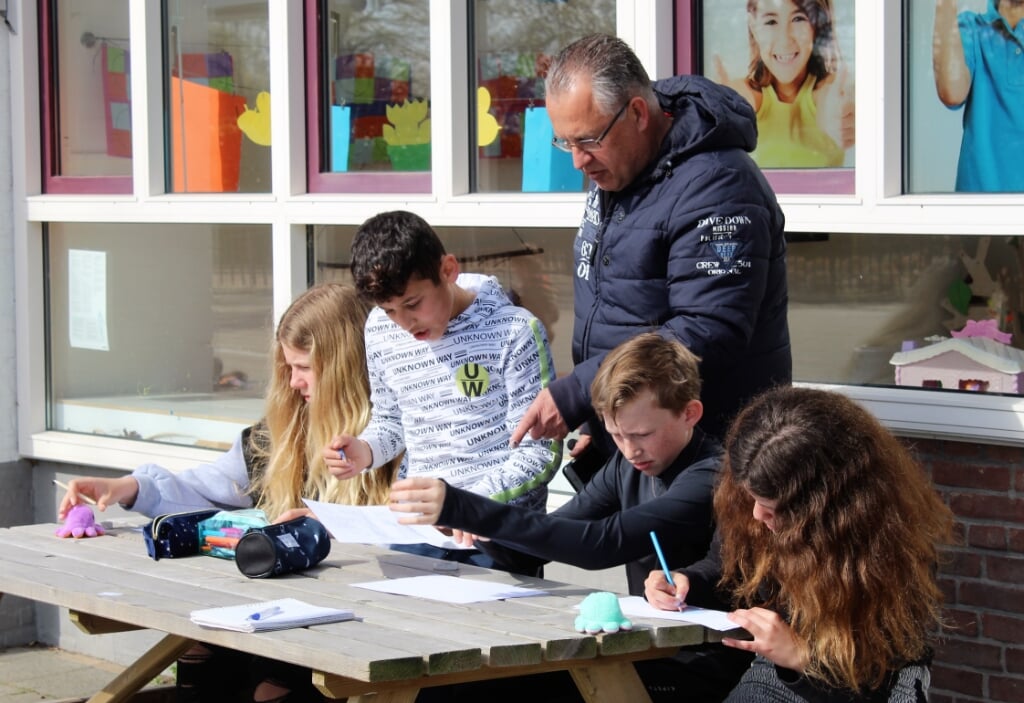 Les krijgen aan de tafel op het schoolplein (Foto: Mirjam Terhoeve).