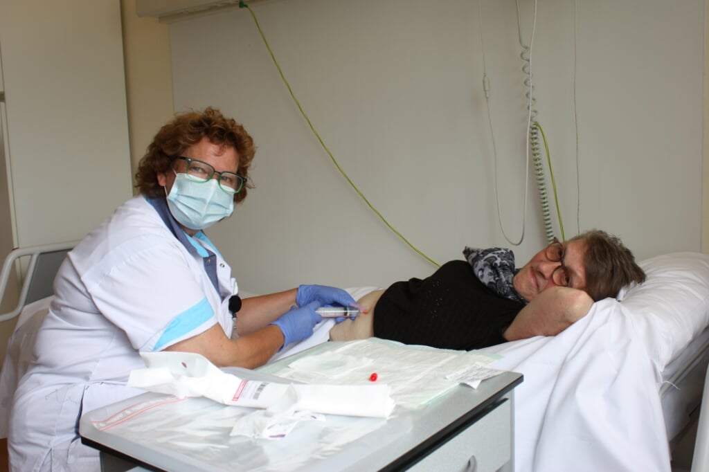 Oncologieverpleegkundige Ineke Fondse geeft Riet Riedijk de eerste injectie (Foto: Kees van Rixoort).