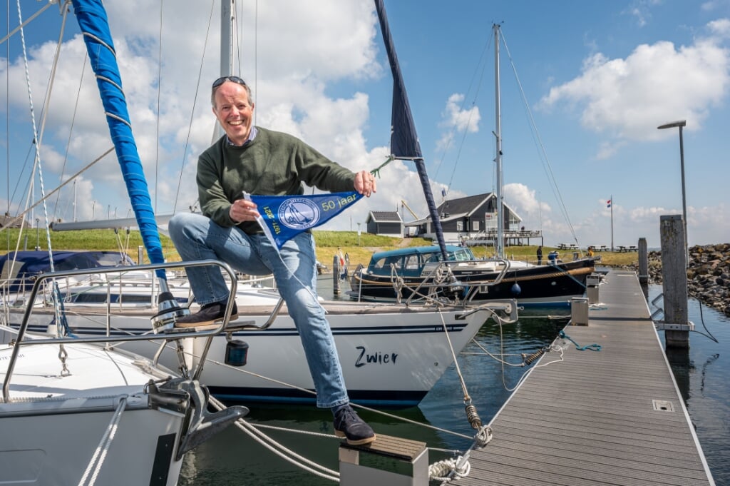 Voorzitter Frederik van der Dussen van WSV Goeree met het jubileumvlaggetje in de Ouddorpse haven (Foto: Wim van Vossen).