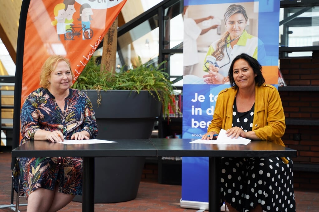 Arjo Hoogwerf (Careyn) en Ingrid (Albeda Zorgcollege) ondertekenen de intentieverklaring bij bibliotheek de Boekenberg te Spijkenisse.