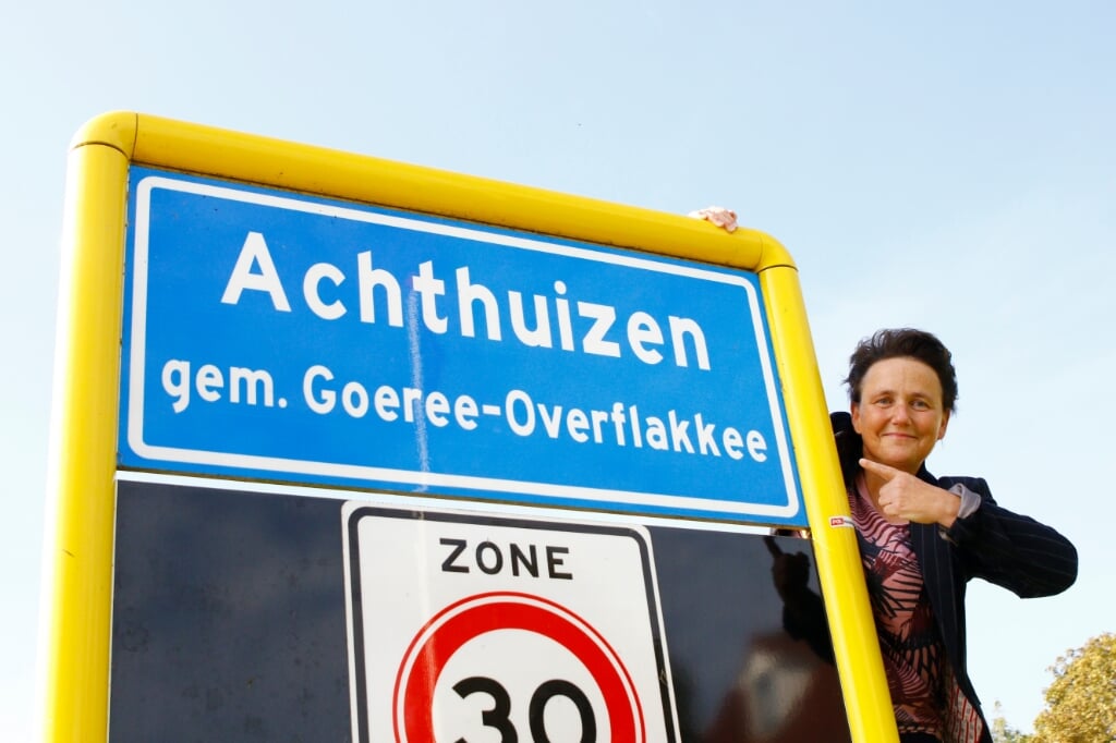 Mariëlle Hornstra van de gemeente bij een plaatsnaambord in Achthuizen (Foto: Mirjam Nelis).