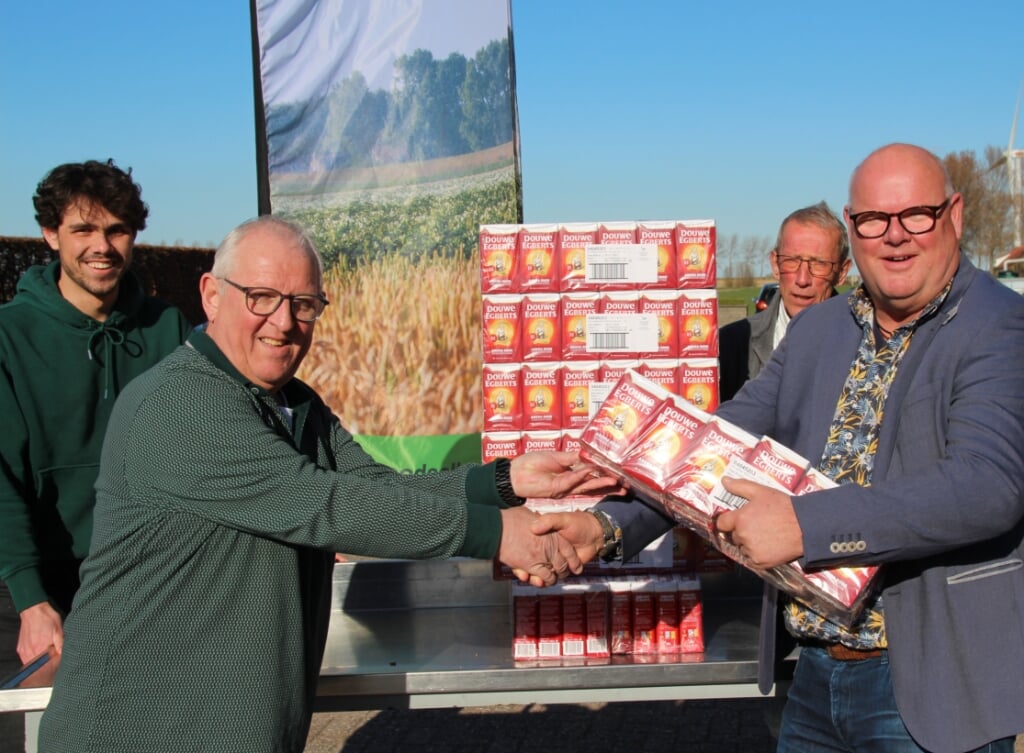 President van de Lions Club Goeree-Overflakkee, Bert de Boer (r), overhandigt aan Martin Ista, vrijwilliger bij de voedselbank, 1.260 pakken DE-koffie. 