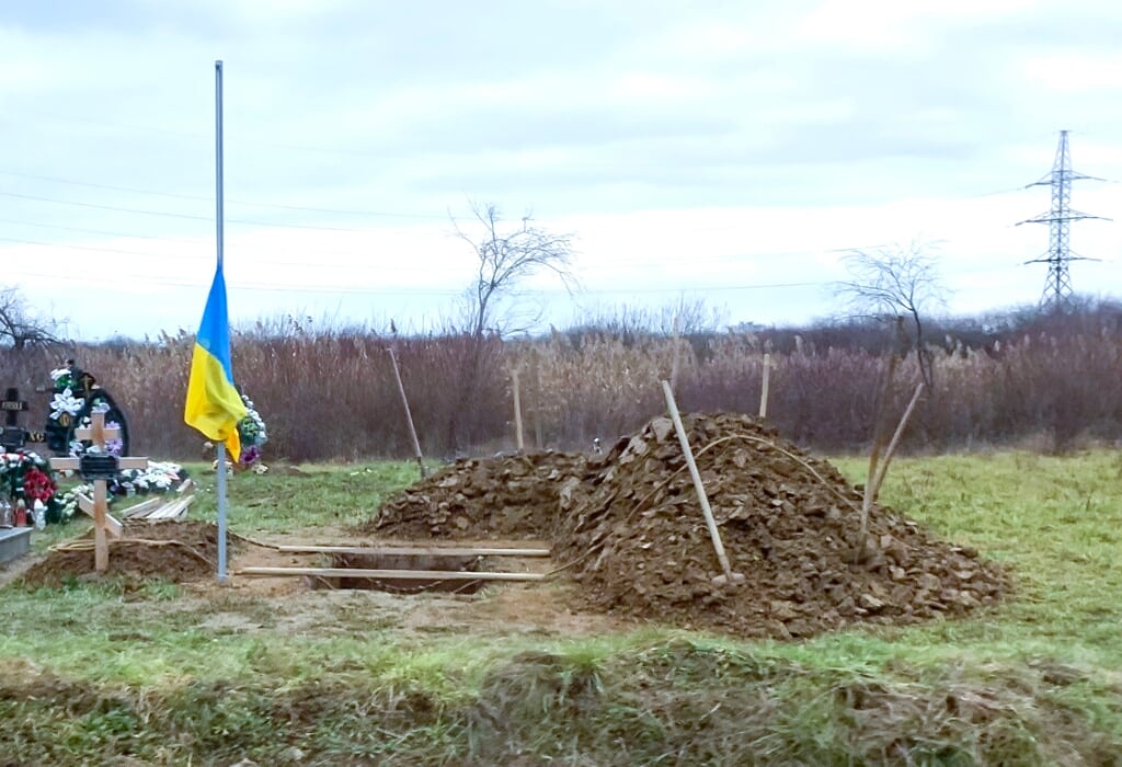 Sporen van de oorlog: Steeds meer graven waar jonge gesneuvelde soldaten worden begraven. Links de Oekraiense vlag bij het graf.