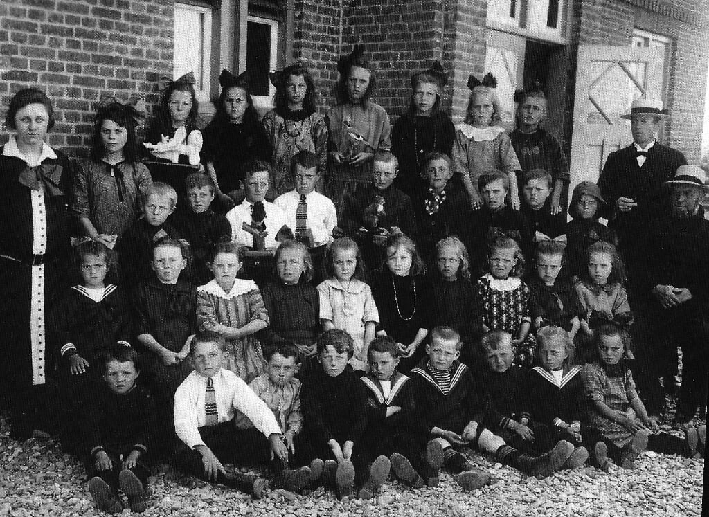 Eén van de eerste schoolfoto's uit 1927. Links juffrouw van den 
Born. Rechts meester van der Velde en voor hem bestuurslid Wijn Redert.