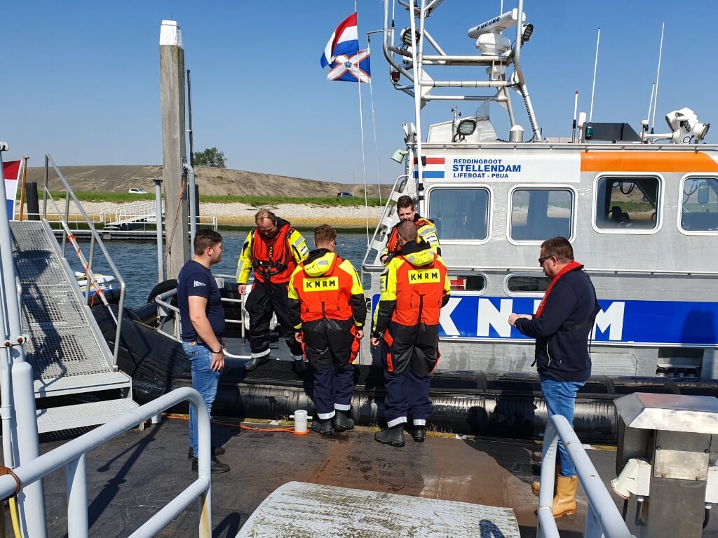 KNRM-vrijwilligers staan bij de boot klaar voor om bezoekers op te vangen.