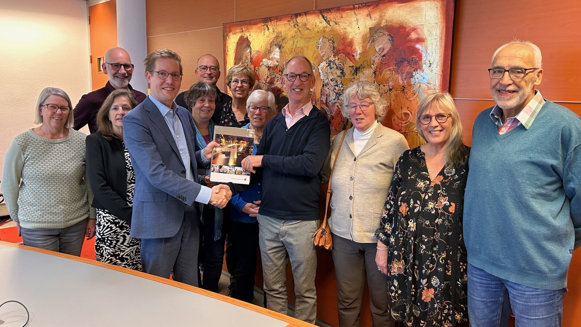 Wethouder Arno Bonte overhandigt de getekende koopovereenkomst voor het perceel aan het Diepenbroek aan de leden van de CPO-vereniging Buitengewoon