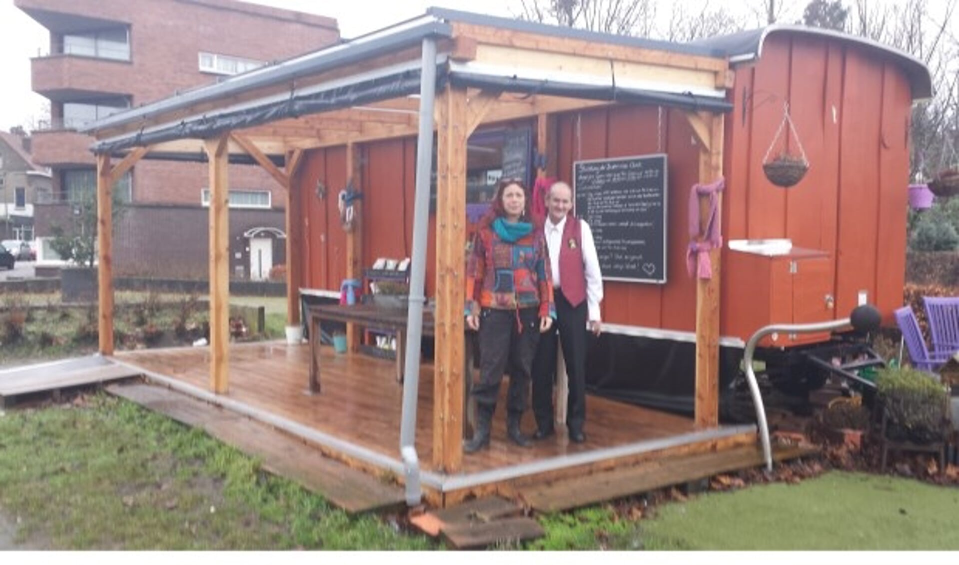 Mary Brokken en buurman Albert bij de mobiele buurtpost bedoeld voor de wijk  Oost. Een Pipowagen met gratis koffie en zelfgemaakte appeltaart is het idee. De bouwkeet blijkt een succes te zijn. 