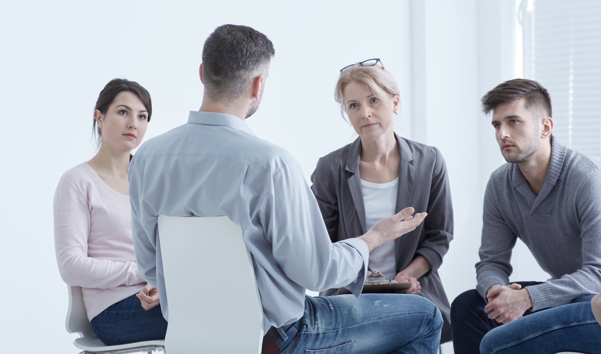 Distressed young man confiding to his supporting psychotherapy group