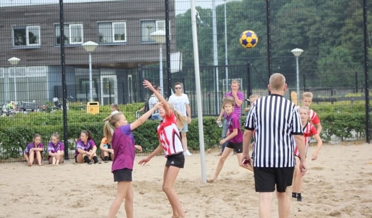 De jeugd is superenthousiast over het spelen van korfbal op zand. 
