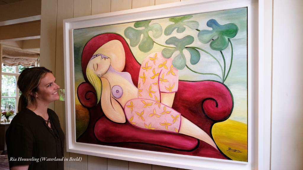 Een bezoekster van de Broeker Kunstroute 2018 bewondert een kunstwerk van Erik Renssen;
Dreaming woman in pantaloon (2018