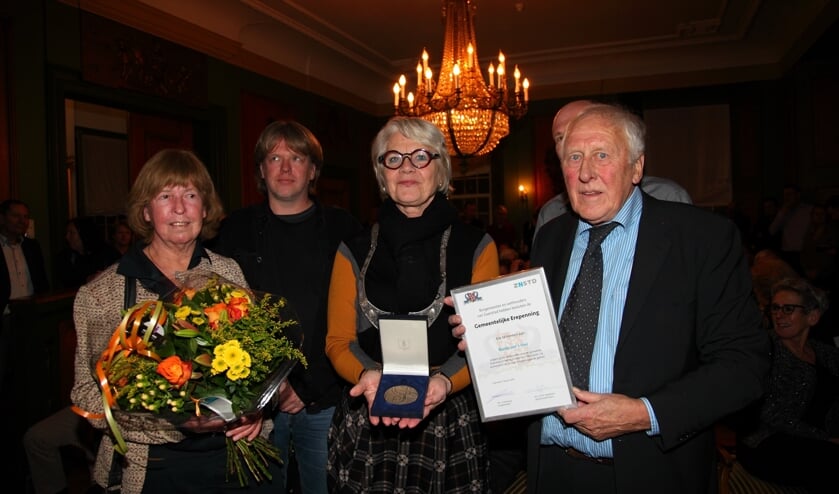 Een trotse en ontroerde Van 't Veer (links) met de Erepenning van Zaanstad.