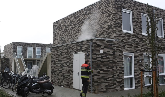 Rook is te zien, komend uit een bijgebouwtje.
