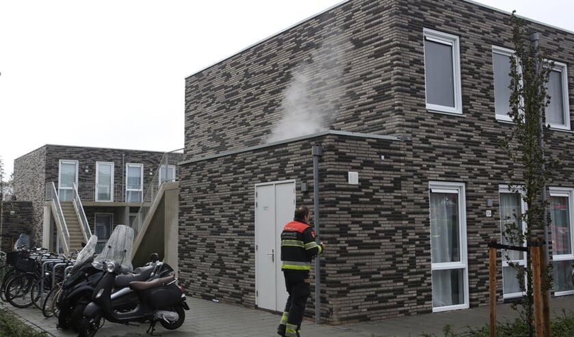 Rook is te zien, komend uit een bijgebouwtje.
