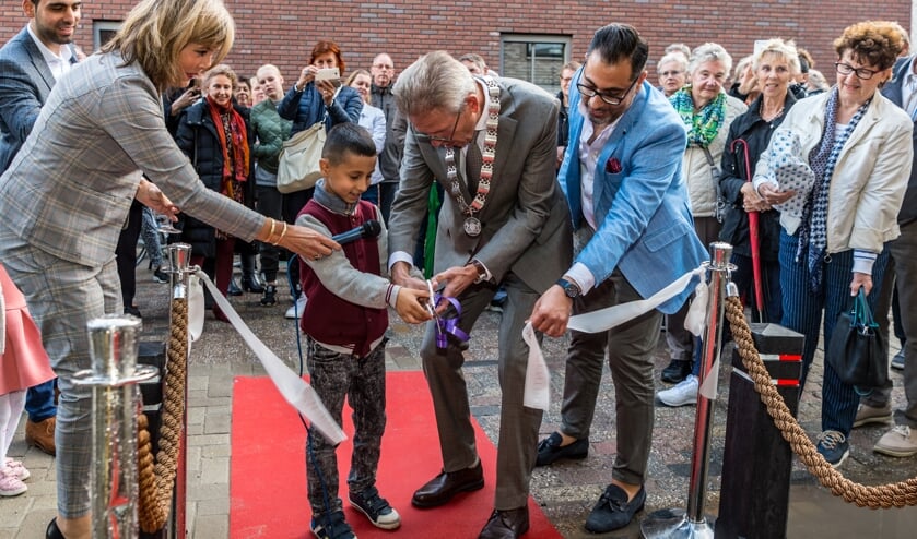 Met hulp van de burgemeester (midden) en initiatiefnemer Ahmed Muhamed knipt een van de kinderen van Ahmed het lintje door.