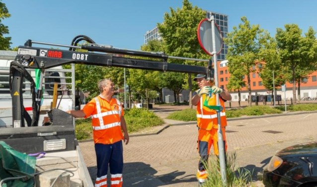 Medewerkers van De Waterwolf op straat aan het werk.