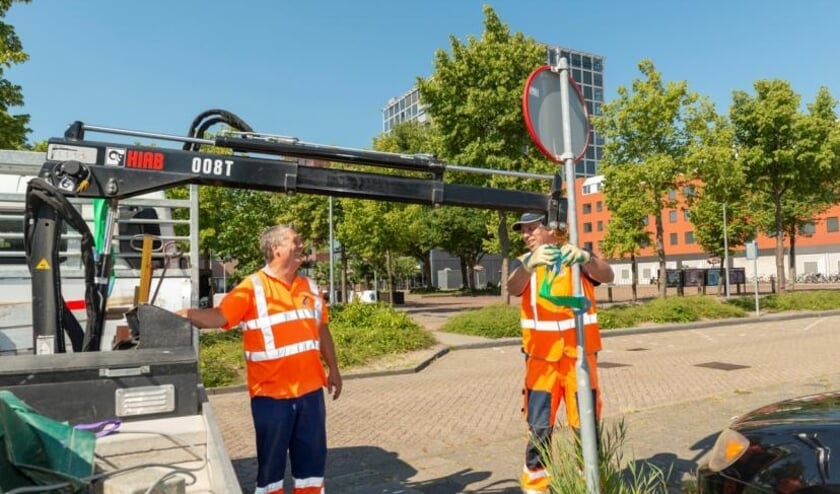 Medewerkers van De Waterwolf op straat aan het werk.