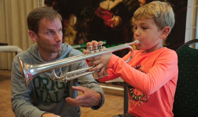 Joep (7) probeert de trompet uit bij trompetdocent Erik Torrenga.