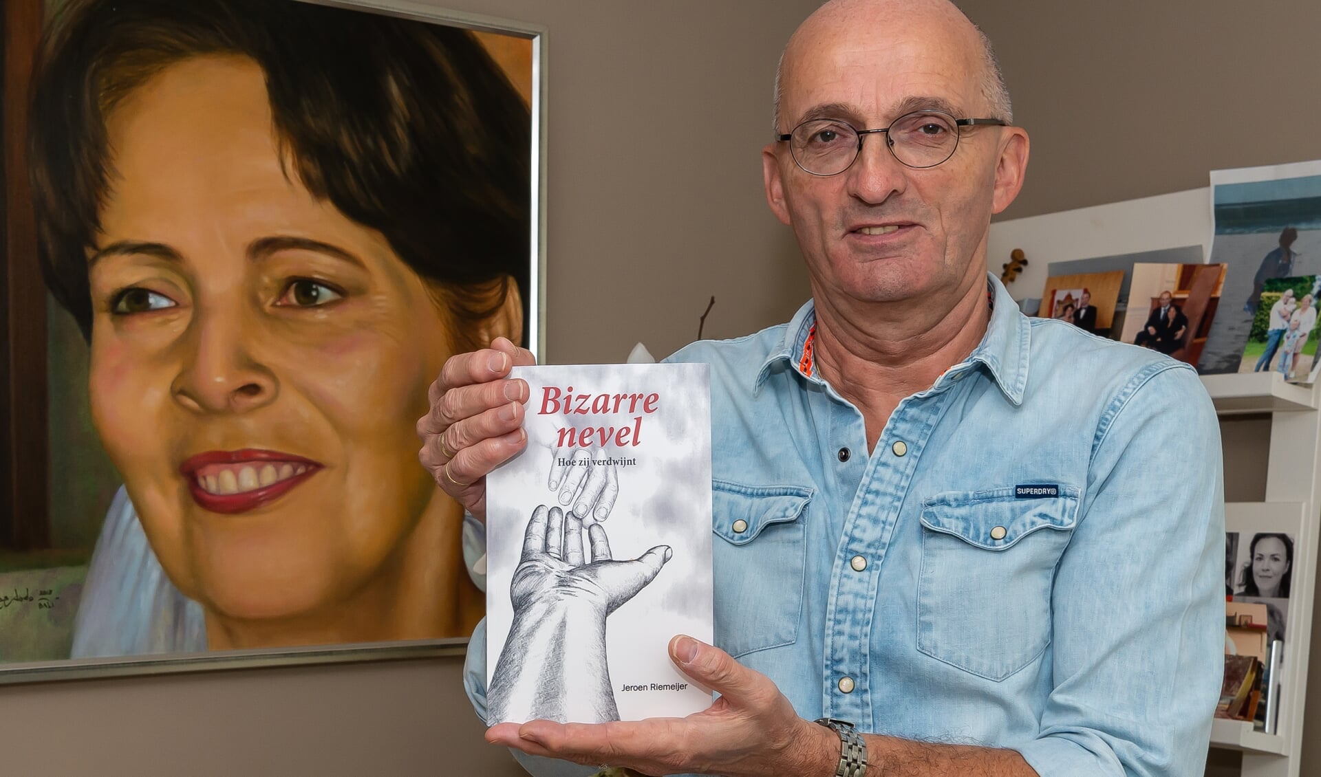 Jeroen Riemeijer met boek voor het portret van zijn zo geliefde Joke. Het in Maleisië gemaakte portret staat in de achterkamer van Jeroens huis.