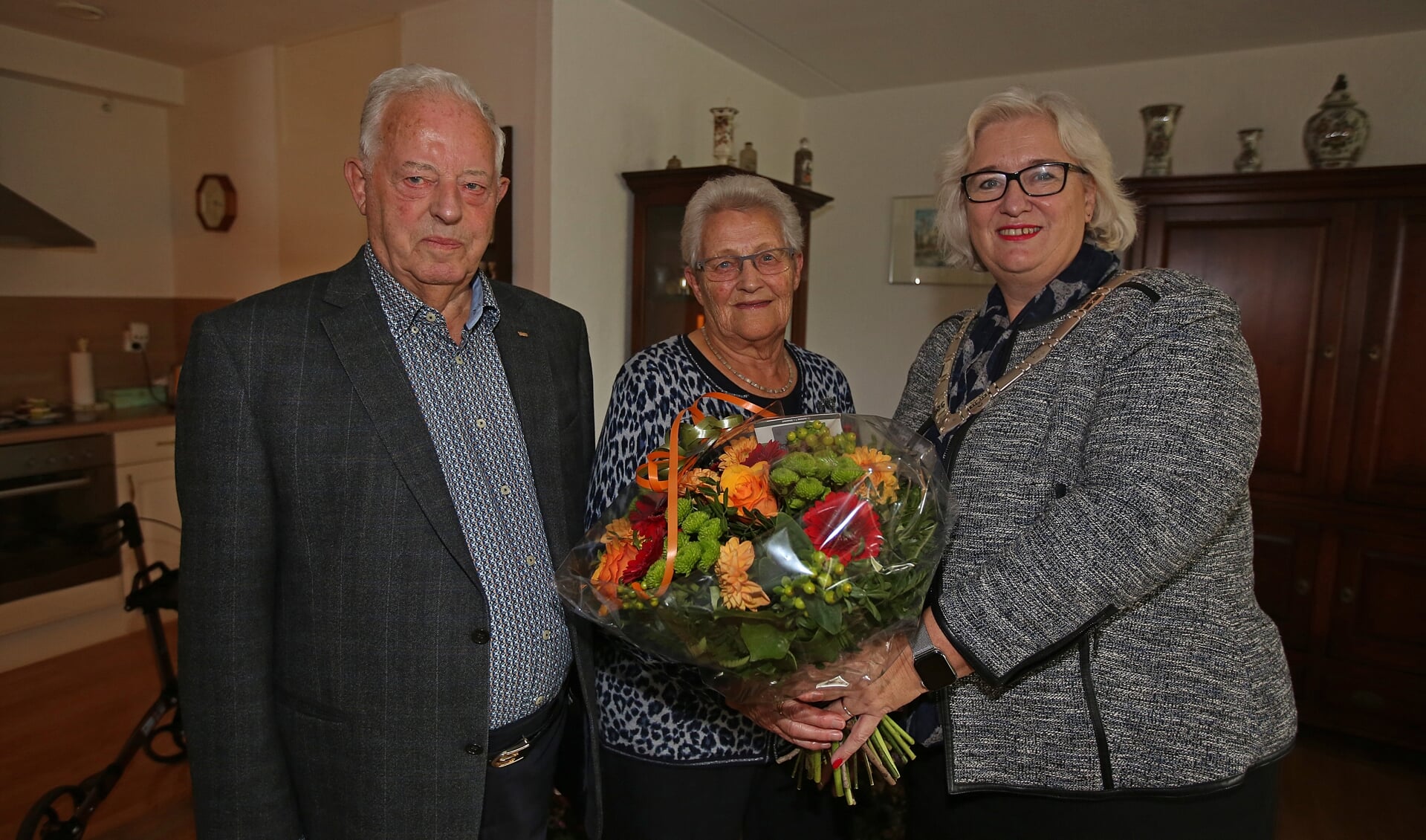De burgemeester brengt bloemen en de felicitaties over aan Arie en Geertje van der Maarl. 
