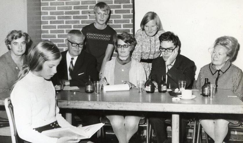 Brenda Terpstra die in oktober 1969 als elfjarige scholiere in hetkader van de Kinderboekenweek een voorleeswedstrijd won. Namen van de juryaan tafel zijn: V.l.n.r.: Mw. de Jong-den Baas, de Heer Kleinbloesem(bestuurslid bieb), Maud Stolk, Adrie Geus (administratie bieb). Helemaalrechts directeur Mw. Wilhelm-Glas.