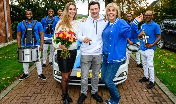 Johan uit Berkhout wordt door Irene Moors samen met een brassband verrast met een nieuwe auto.