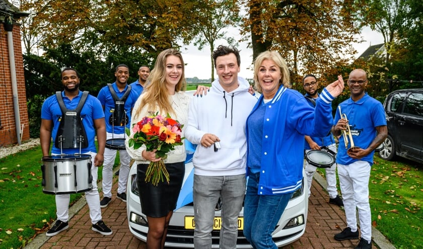 Johan uit Berkhout wordt door Irene Moors samen met een brassband verrast met een nieuwe auto.