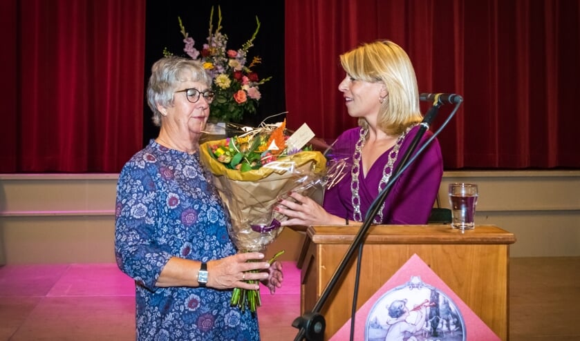 Bloemen horen er natuurlijk ook bij. Netty Wals neemt ze in ontvangst van Mandy Elfferich.