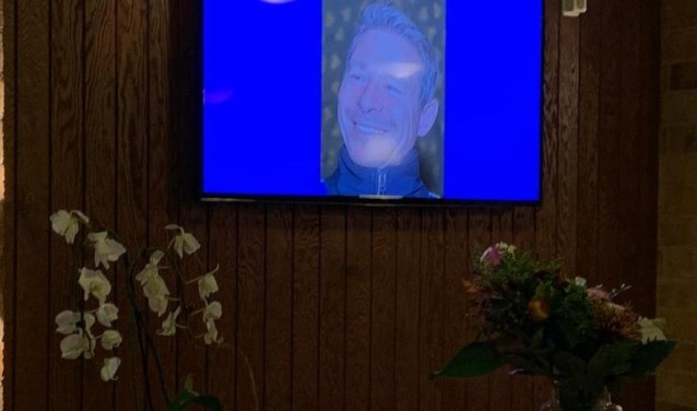 Een foto van Dave Lange is te zien op een scherm in de kantine van DIOS.