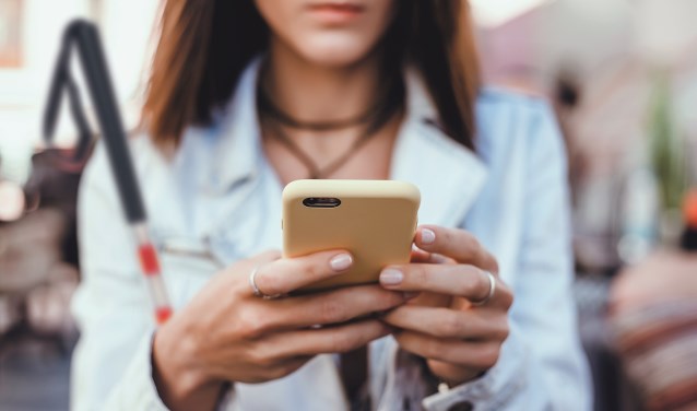 Slechtziende dame met mobiele telefoon.