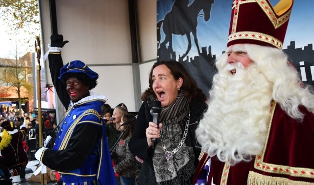 Burgemeester Baltus zingt enthousiast mee met het Heemskerks Sinterklaaslied. Piet zorgt voor een dansje terwijl de Sint aandachtig luistert.