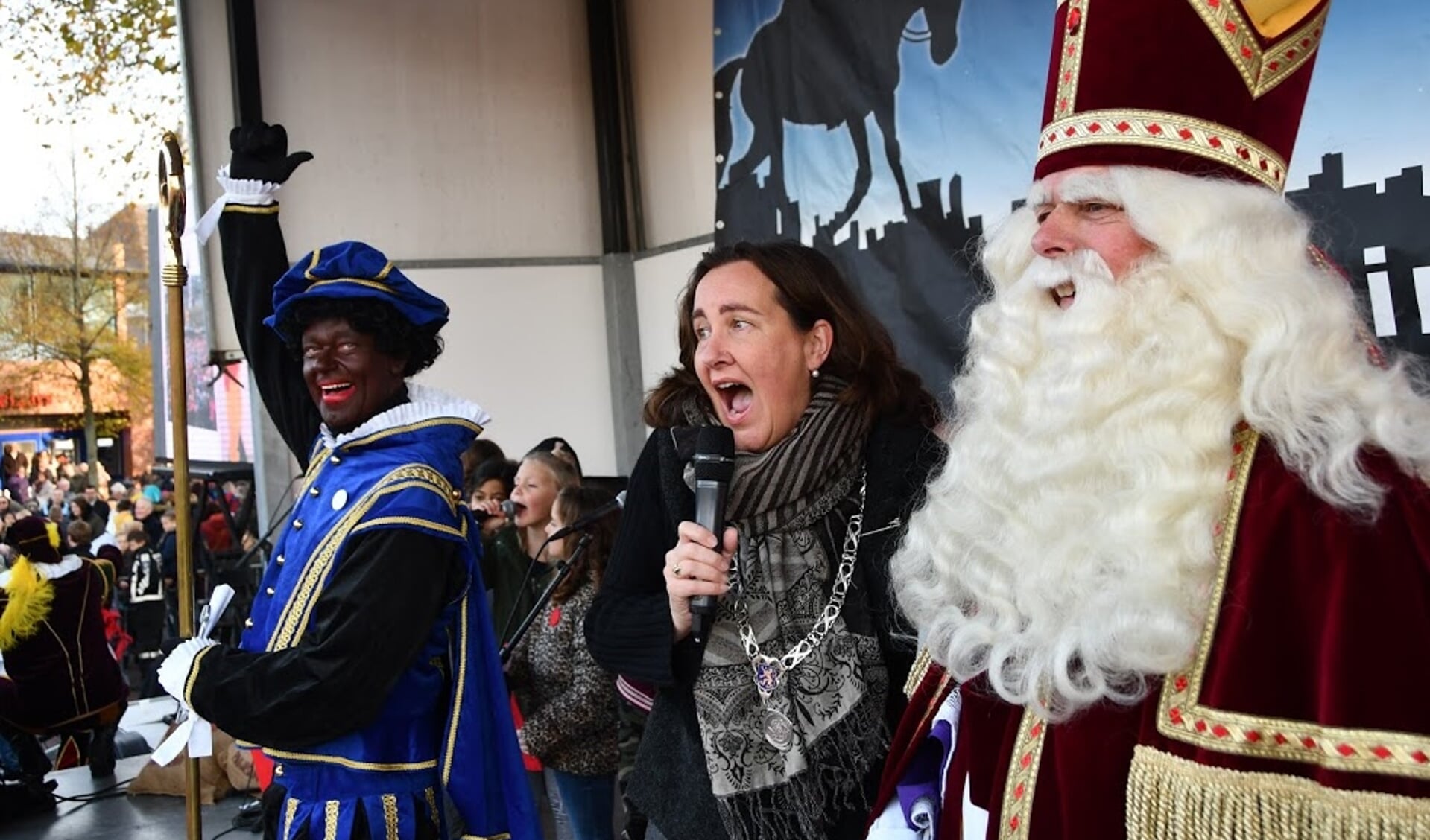 Burgemeester Baltus zingt enthousiast mee met het Heemskerks Sinterklaaslied. Piet zorgt voor een dansje terwijl de Sint aandachtig luistert.