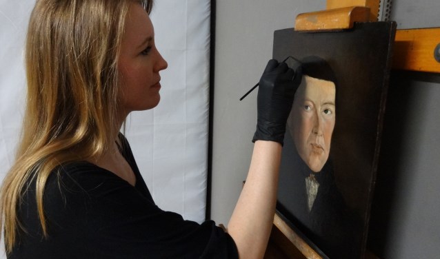 Restaurator Femke van der Knaap werkt aan het Portret van Jacob Kuijper.