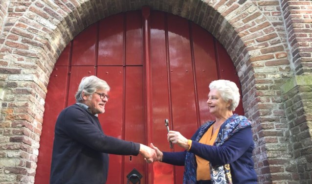 Gerda van der Kolk van de PGMWF draagt de sleutel van de kerk over aan André van Rixel van de Stichting Vrienden van de Hensbroeker Kerk.