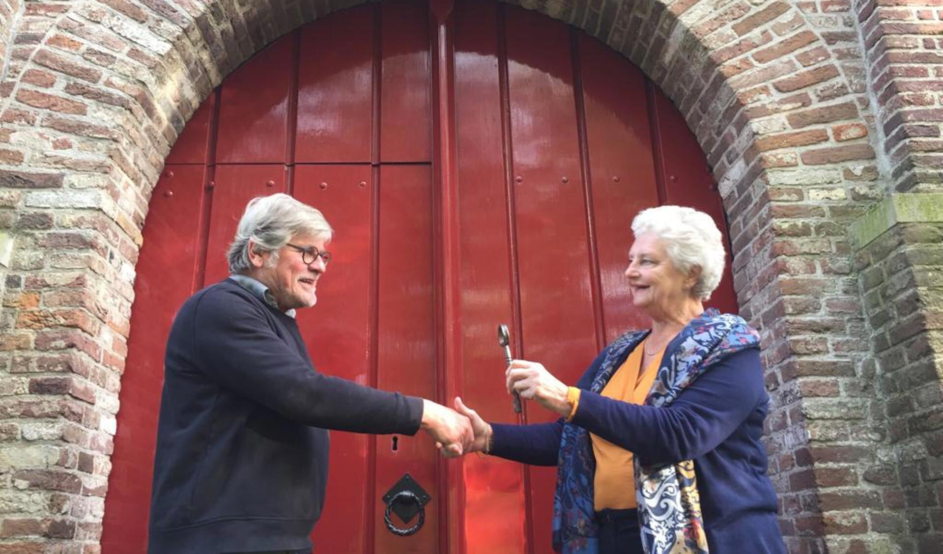 Gerda van der Kolk van de PGMWF draagt de sleutel van de kerk over aan André van Rixel van de Stichting Vrienden van de Hensbroeker Kerk.