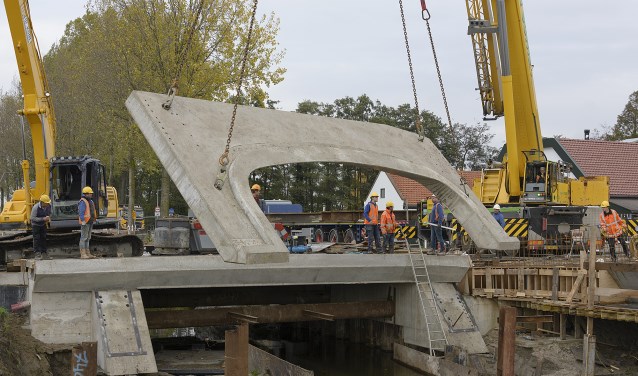 Met grote kranen wordt de taludplaat op zijn plaats gehesen.