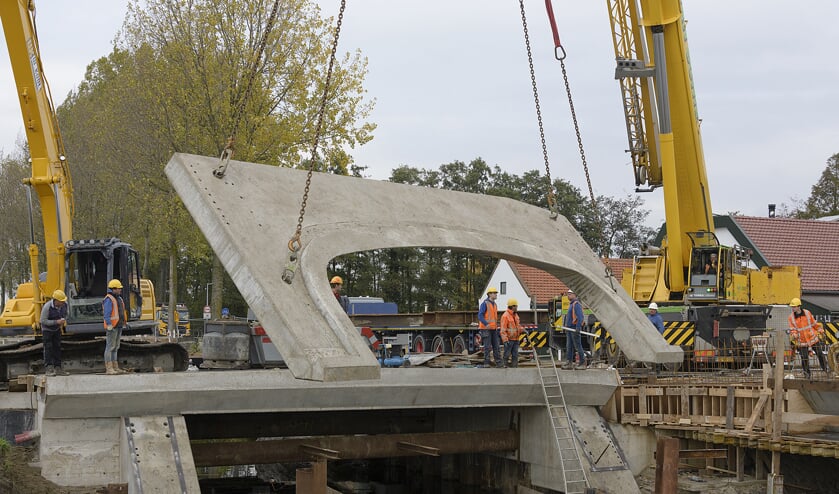 Met grote kranen wordt de taludplaat op zijn plaats gehesen.