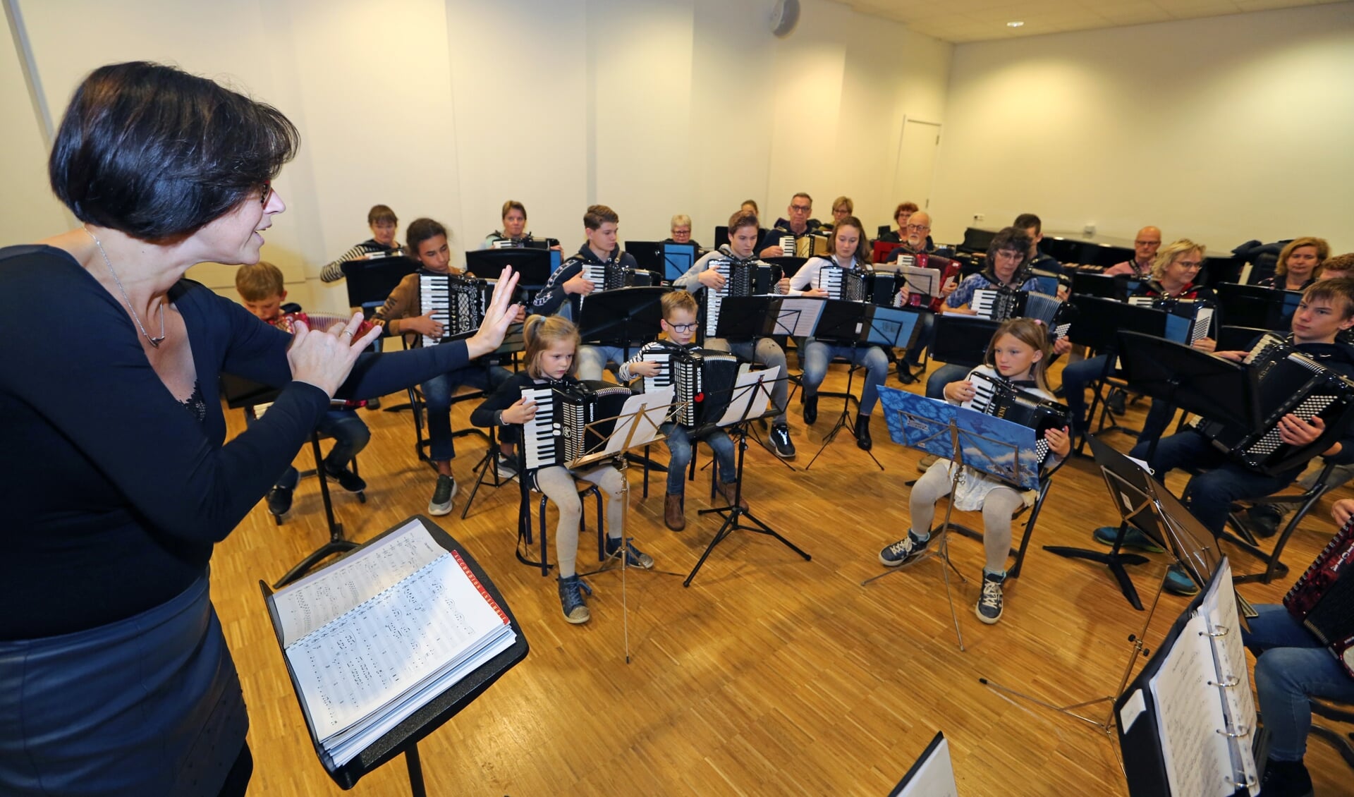 Muziekdocente Bianca IJdema (l) geeft haar accordeonorkest instructies.