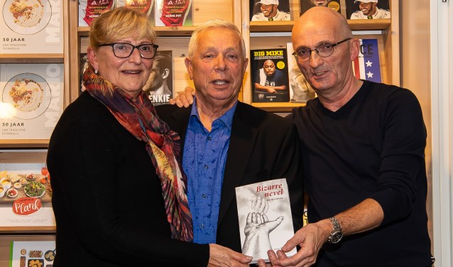 Jeroen Riemeijer (rechts) gaf het eerste exemplaar aan Paul Macco. Links Jeannette, de partner van Macco.