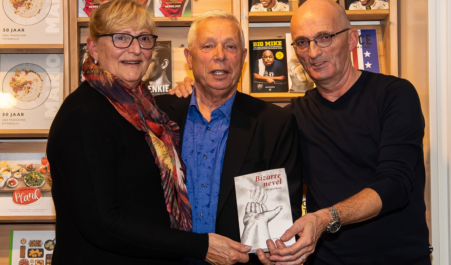 Jeroen Riemeijer (rechts) gaf het eerste exemplaar aan Paul Macco. Links Jeannette, de partner van Macco.