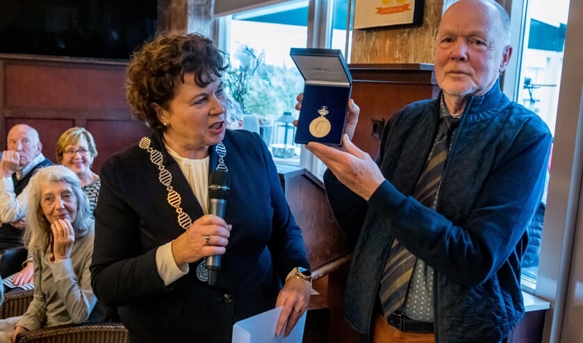 Burgemeester Kompier reikte de erepenning uit aan een zeer verraste voorzitter.