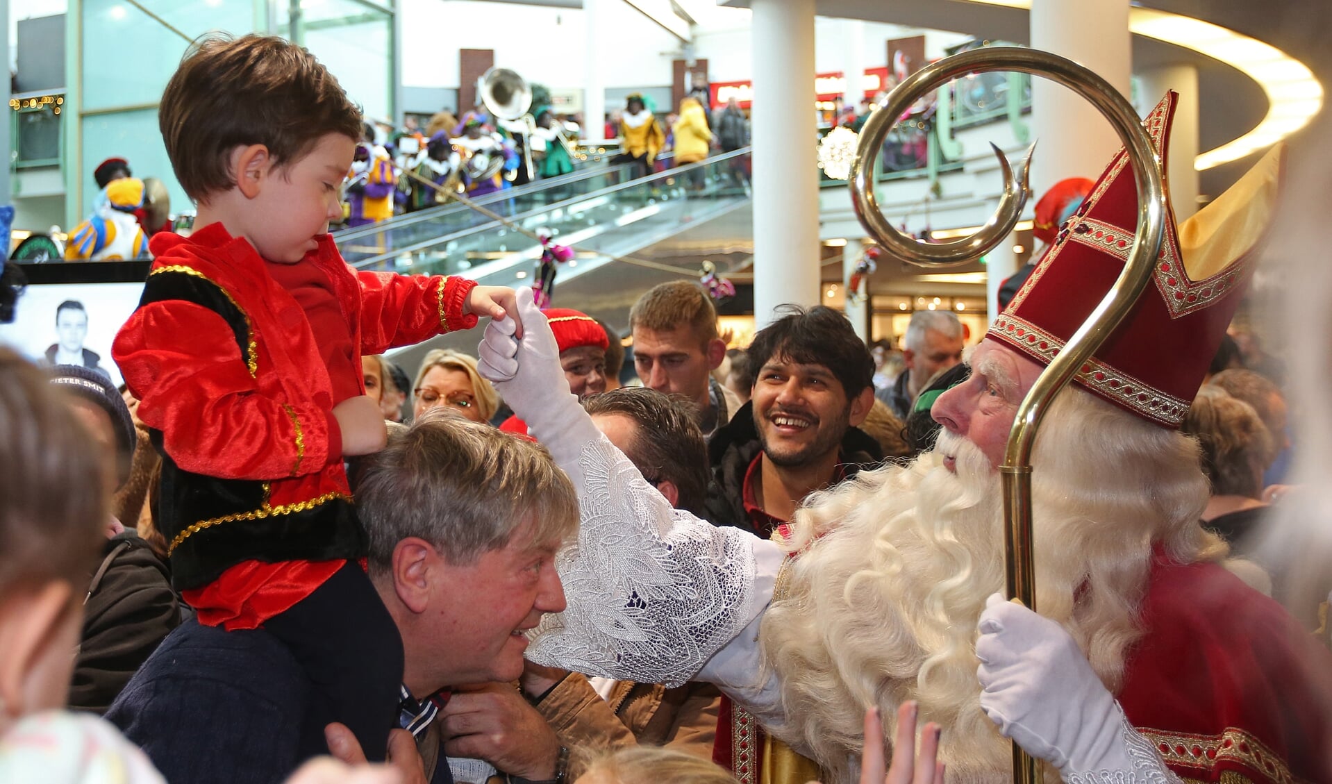 Sinterklaas geeft in De Symfonie één van zijn kleinste fans een hand. 