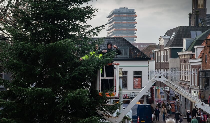Met een hoogwerker gaat men naar boven om alle lichtjes in de boom te bevestigen. n