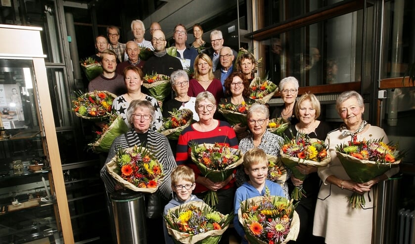 Een grote groep vrijwilligers werd in et zonnetje en in de bloemen gezet.
