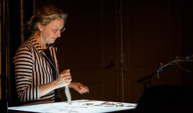 Sylvia Wybenga maakt zandtekeningen.