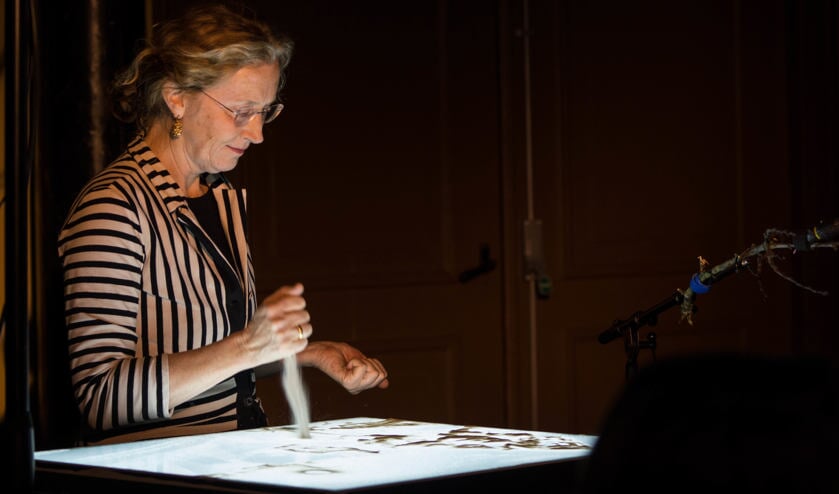Sylvia Wybenga maakt zandtekeningen.