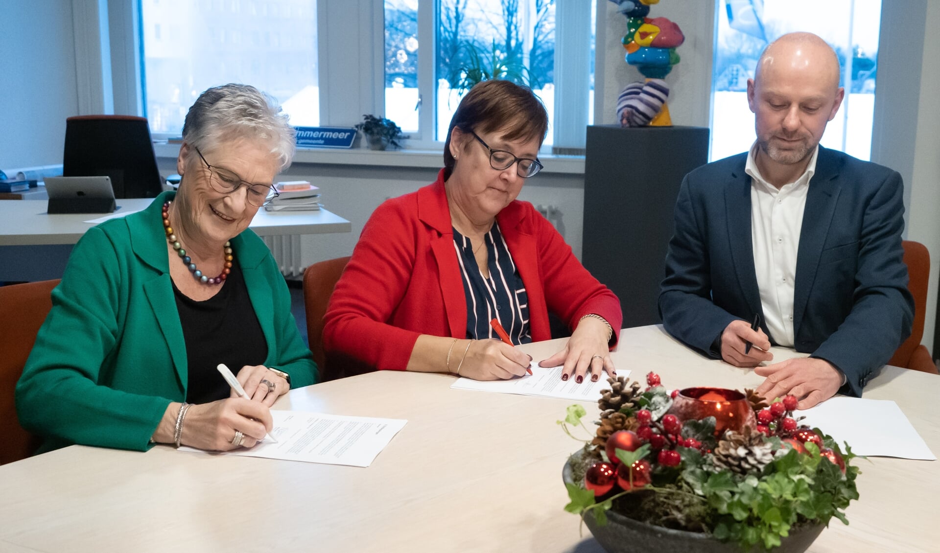 Bea van Doorn (groen jasje) van Alert, wethouder Mieke Booij (rood jasje) en Danny Wijnbelt van Woningcorporatie Eigen Haard. 
