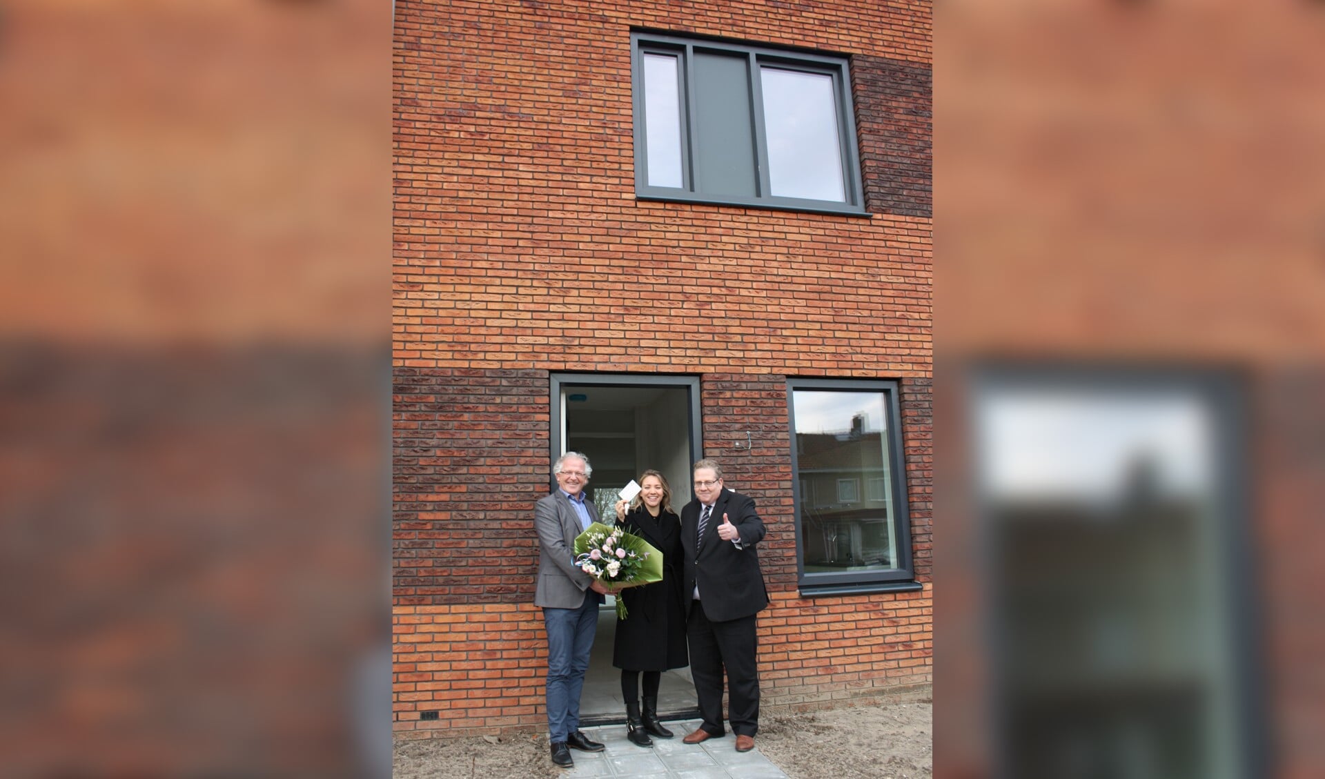 Wethouder Paul Slettenhaar en Dick Tromp, directeur-bestuurder van Kennemer Wonen heten mevrouw Van Diepen van harte welkom.
