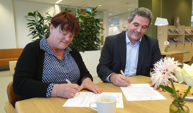 Managers Minouche Rodgers (Heliomare) en Arne Theunissen (Odion) tekenen het samenwerkingsconvenant.