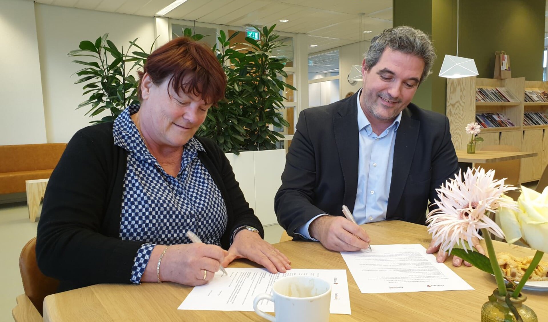 Managers Minouche Rodgers (Heliomare) en Arne Theunissen (Odion) tekenen het samenwerkingsconvenant.